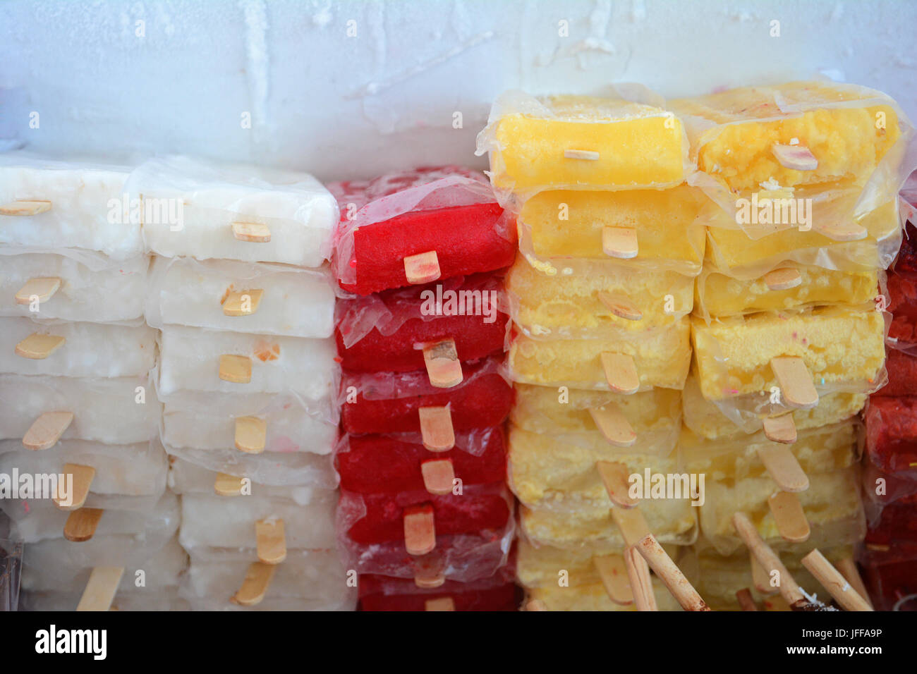 Gefrorene bunte Eisfrucht aromatisierte Eis-Eis-Eis mit Stöcken in gestapelt Kühler für Display Stockfoto