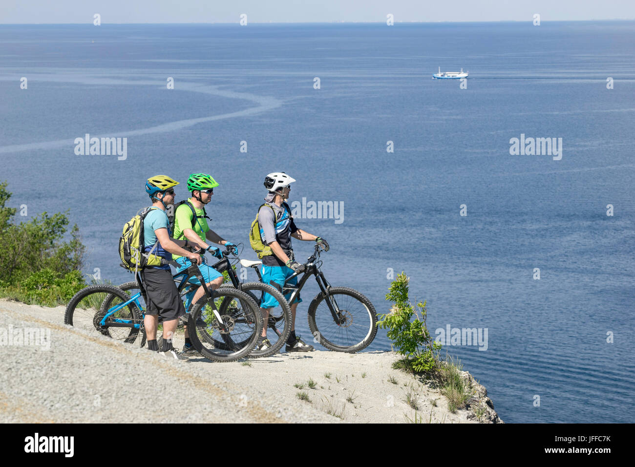 Reife Biker mit Blick auf Meer im stehen am Rand der Klippe Stockfoto