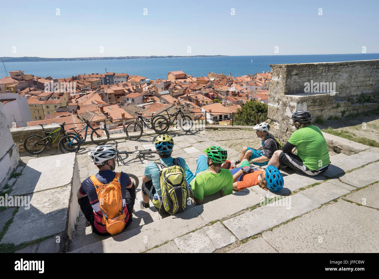 Biker auf der Treppe sitzen und auf der Suche nach einem überlasteten Stadt Meer Stockfoto