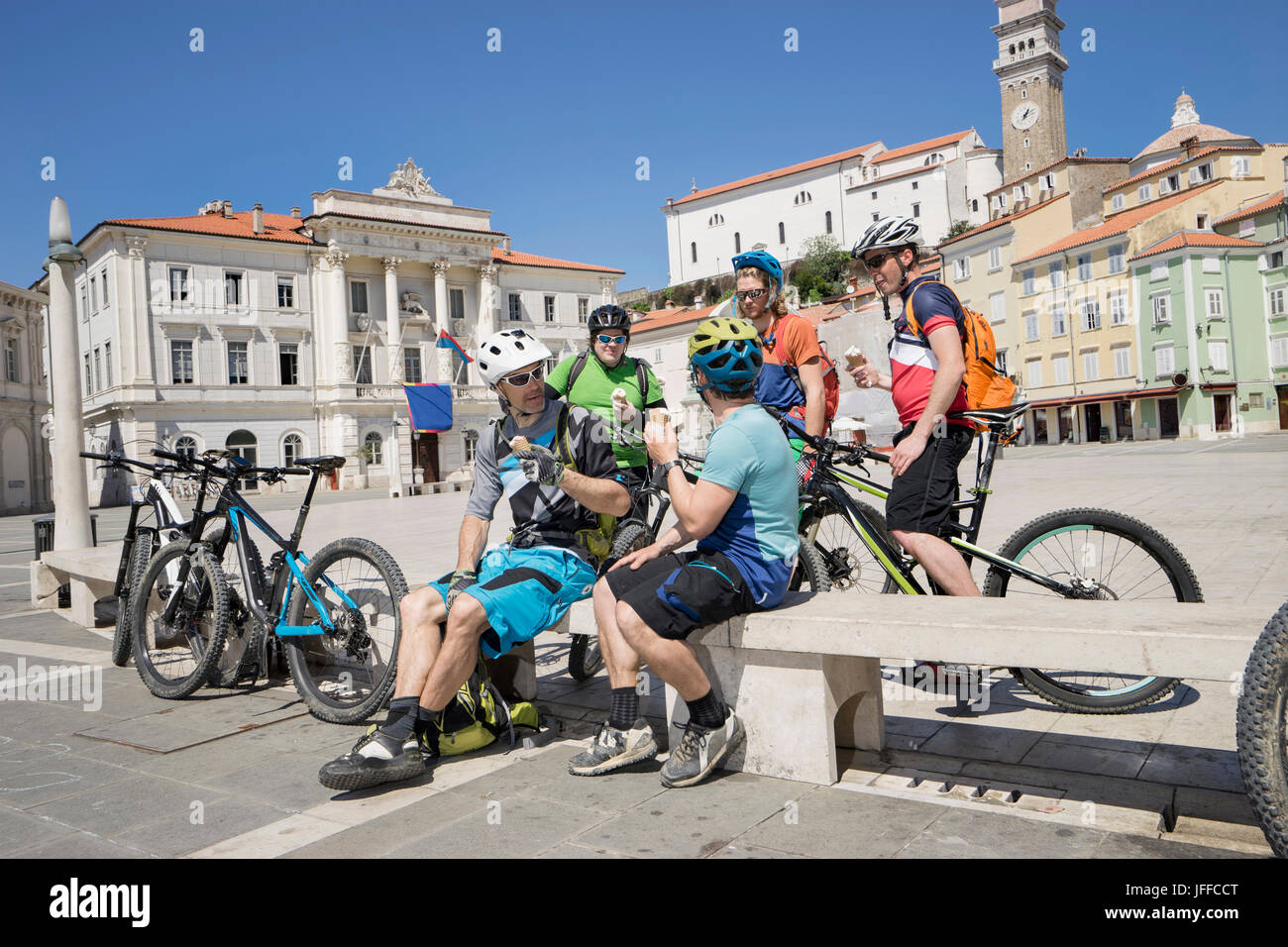 Mountainbiker, Eis essen, auf Bank sitzend Stockfoto