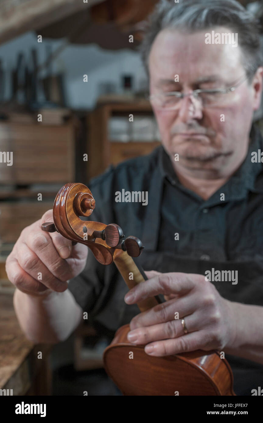 Handwerker in der Werkstatt untersuchen Violine Stockfoto