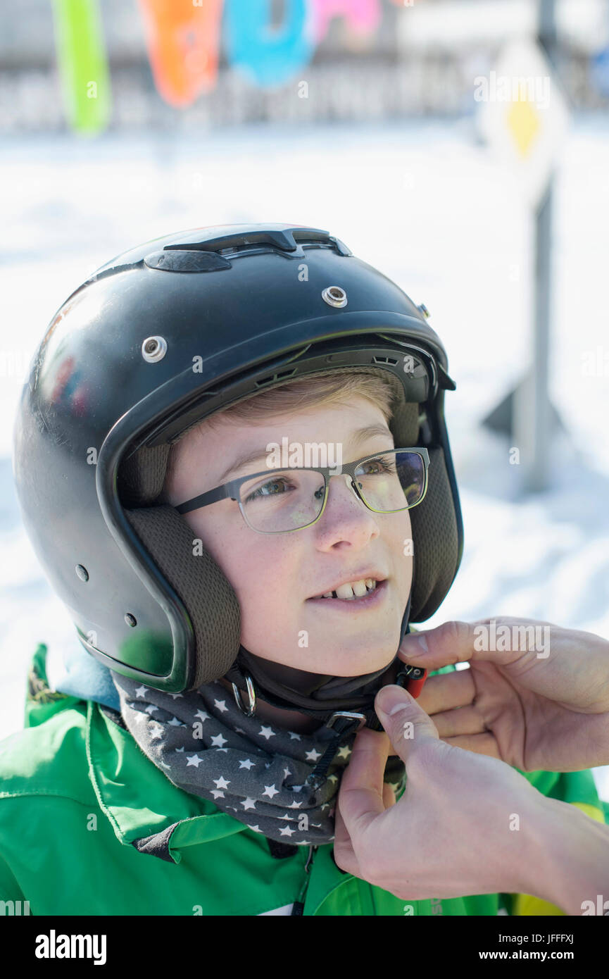 Junge half, indem Man im Helm zu tragen Stockfoto