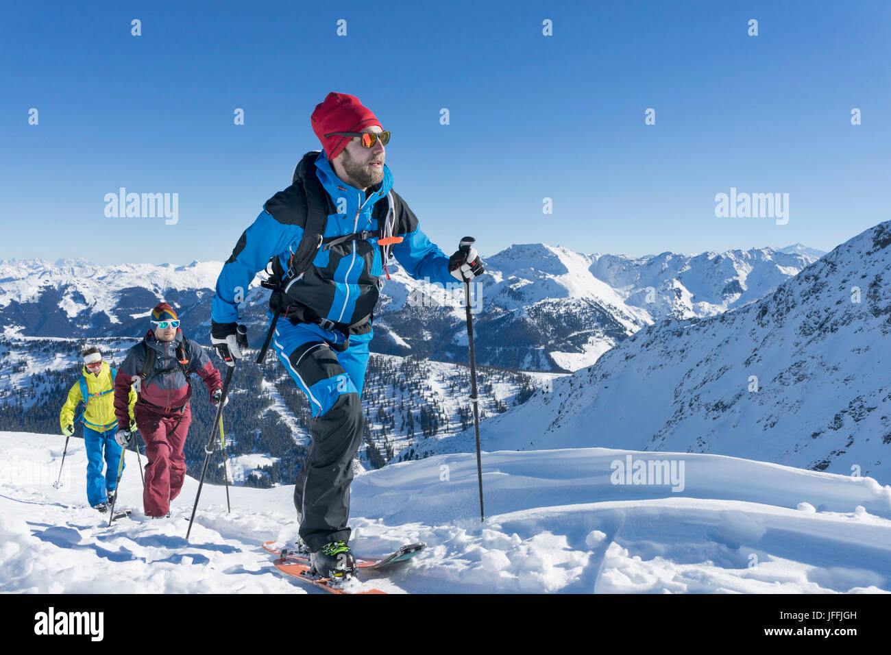 Skifahrer, die zu Fuß auf Schnee Stockfoto