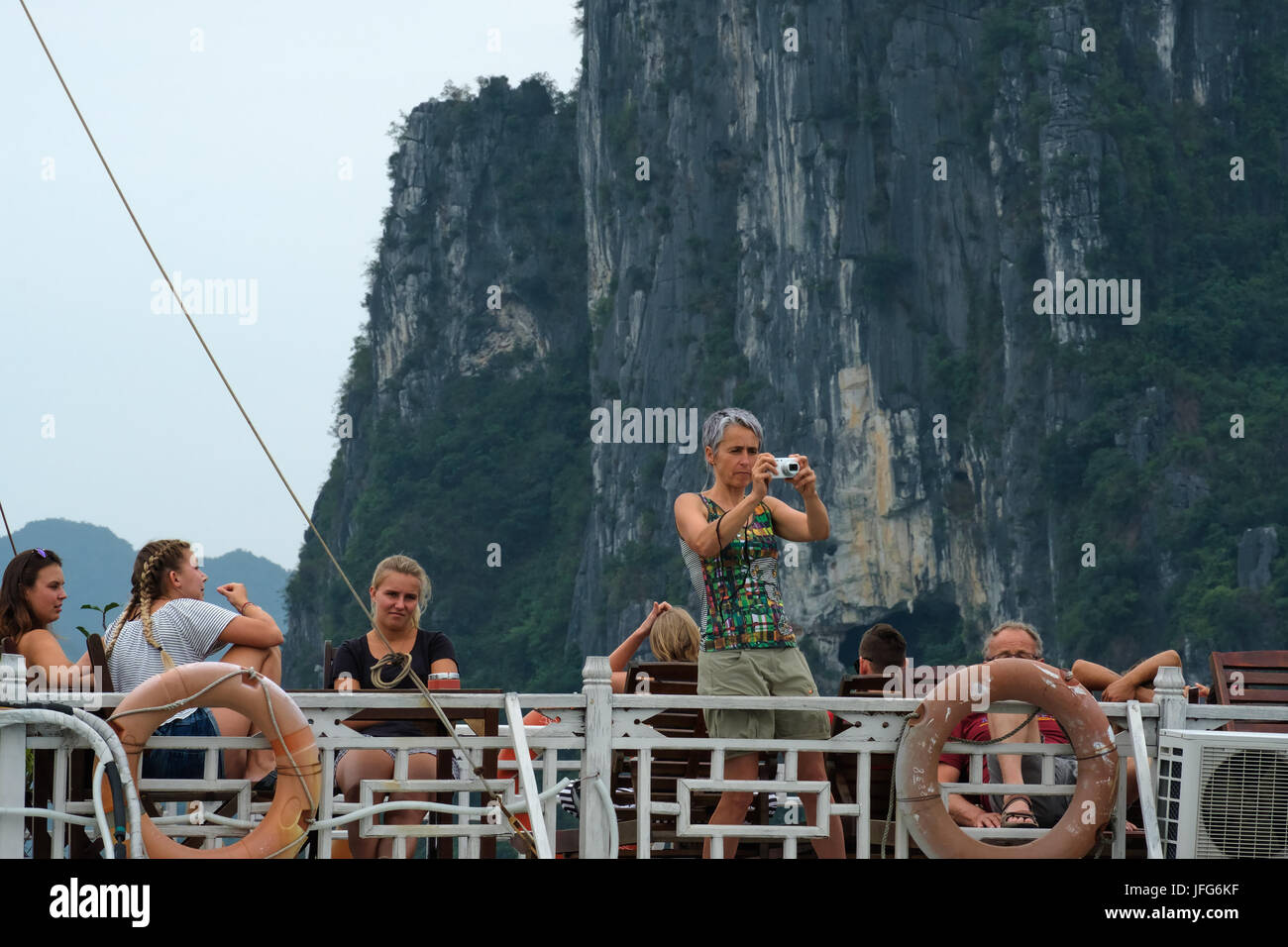 Touristen fotografieren während der Fahrt auf einem Boot in der Halong Bay, Vietnam, Asien Stockfoto
