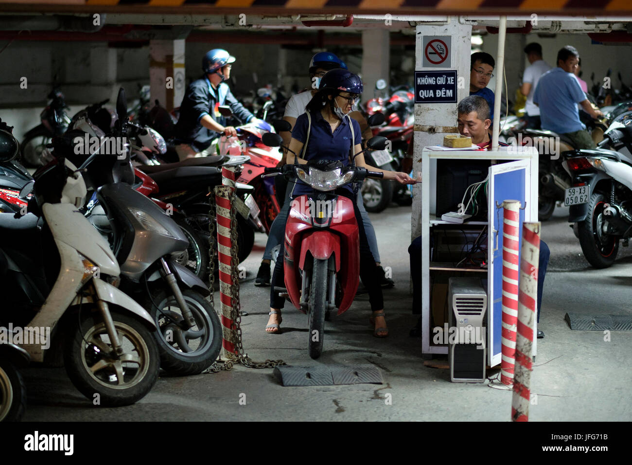 Frau Zahlung für das Parken beim Reiten einen Roller auf den Straßen von Ho Chi Minh City in Vietnam, Asien Stockfoto