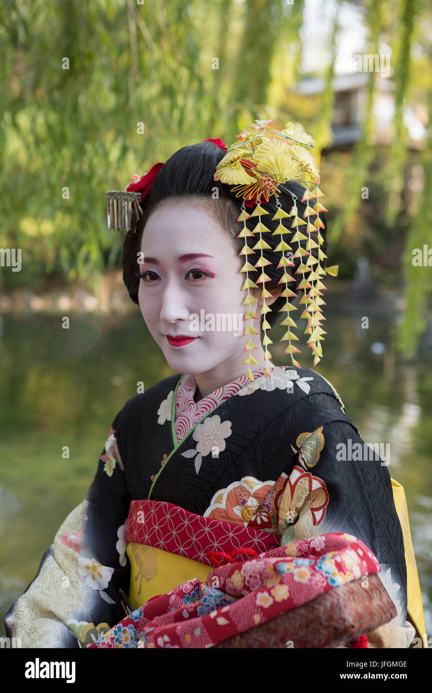 Schöne japanische geisha-frau in traditioneller tracht und make-up.  schwarzer und roter kimono