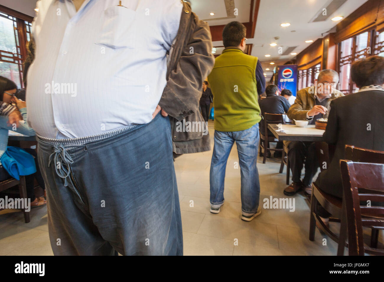 China, Shanghai, übergewichtigen Mannes Magen in einem Restaurant Stockfoto