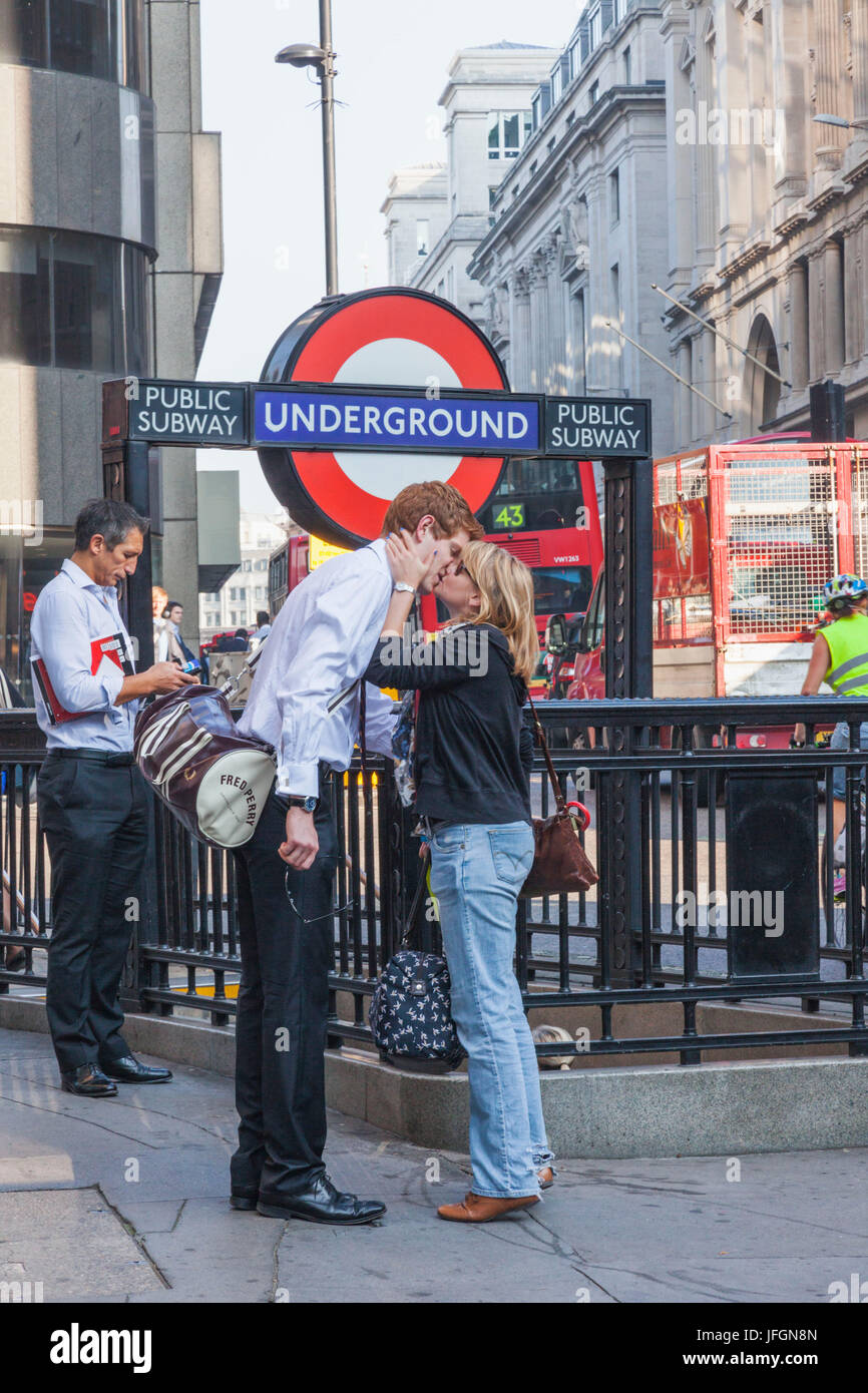 England, London, City of London, paar Küssen auf Wiedersehen vor London Underground Schild Stockfoto