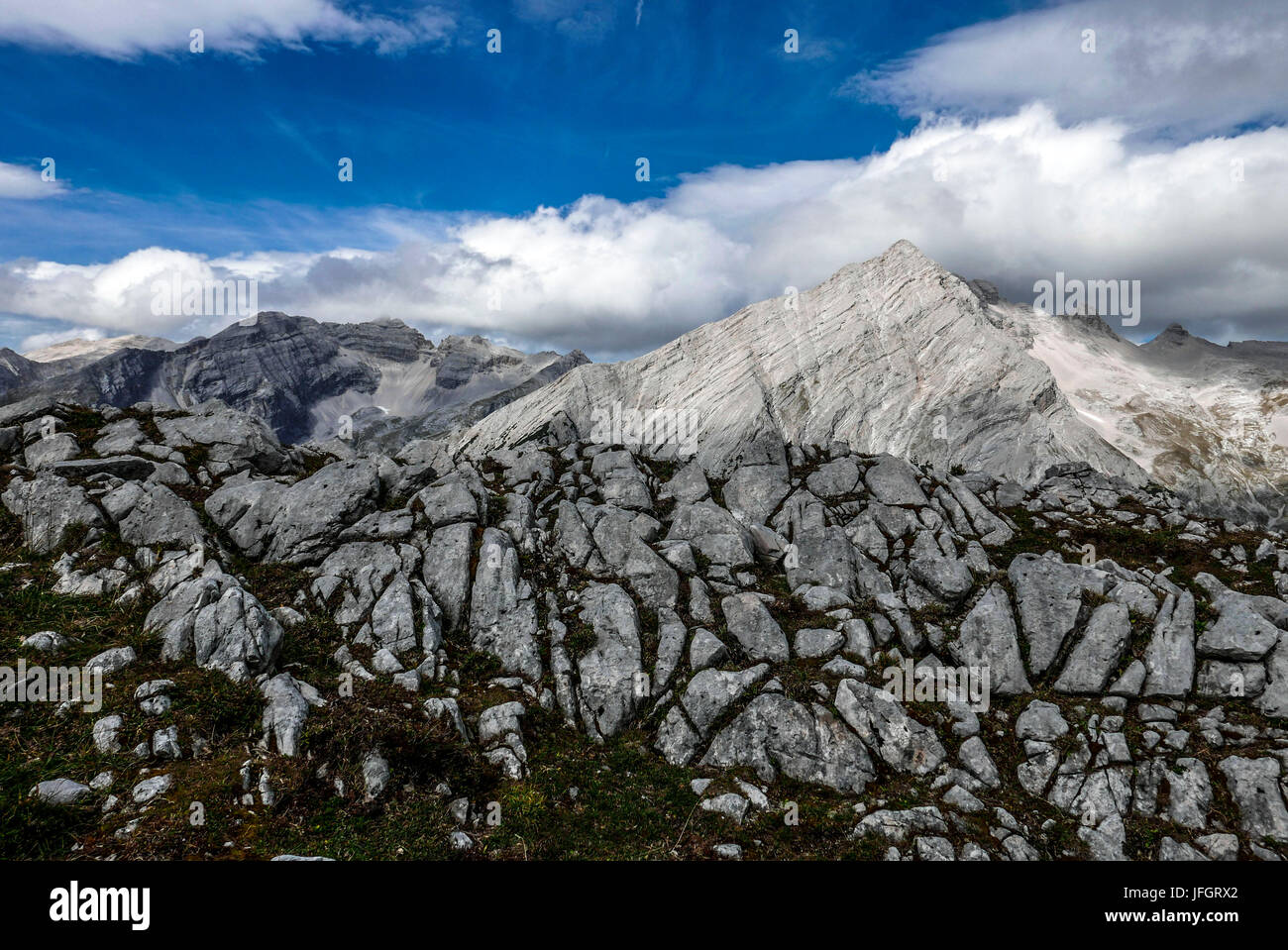 Rock und Gras auf der Rückseite die Wiederholungen Blick auf Kaltwasserspitzet in Wolken und südliche Sonnenspitze, Karwendel, Tirol, Stockfoto