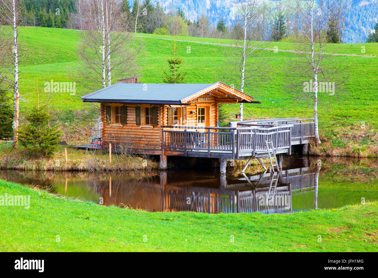 kleines Landhaus im Teich, Blockhütte, Hütte, teilweise aufbauend auf Stelzen, Birken, Frühjahr, Fieberbrunn, Tirol, Österreich Stockfoto