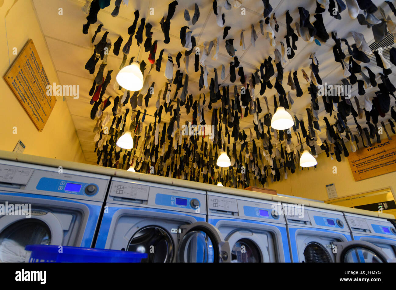 Waschsalon in der Äußere Neustadt, in der Waschmaschine Machin vergessen  Socken von der Decke hängen, Deutschland, Sachsen, Dresden Stockfotografie  - Alamy