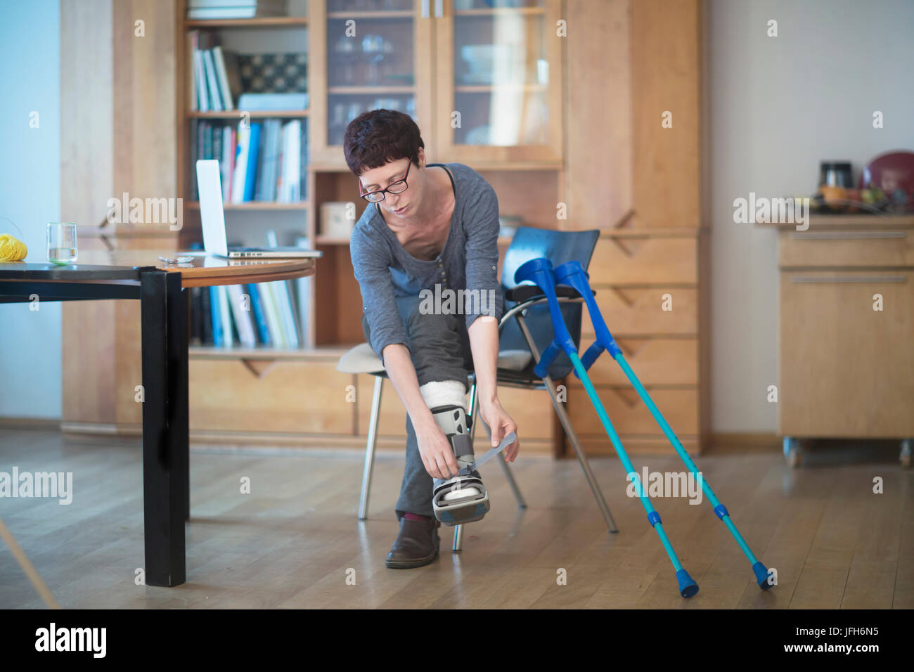 Frau mit gebrochenem Bein anpassen ihrer Beinschiene Stockfoto