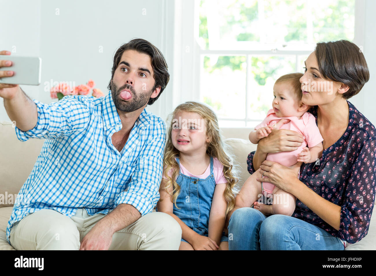 Familie machen Gesichter während der Einnahme Selfie auf sofa Stockfoto