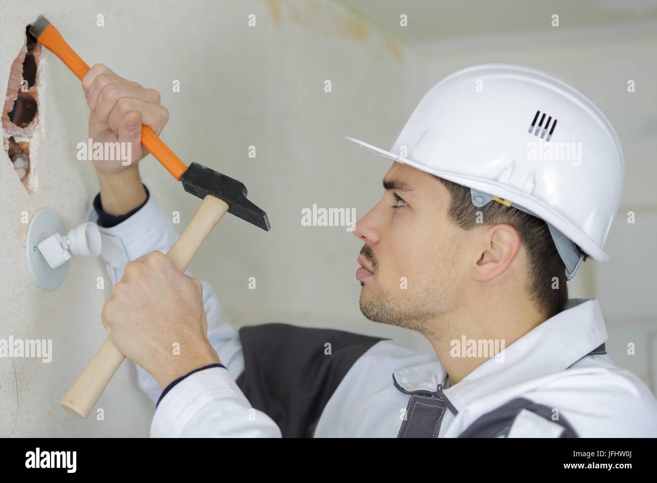 Meißel-Arbeiter in den Putz zu brechen Stockfoto