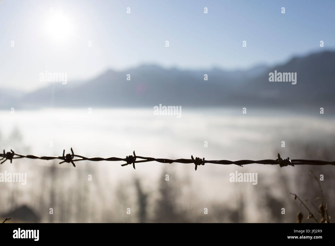 Stacheldraht, Sonne, Nebel, Berge, Horizont Stockfoto