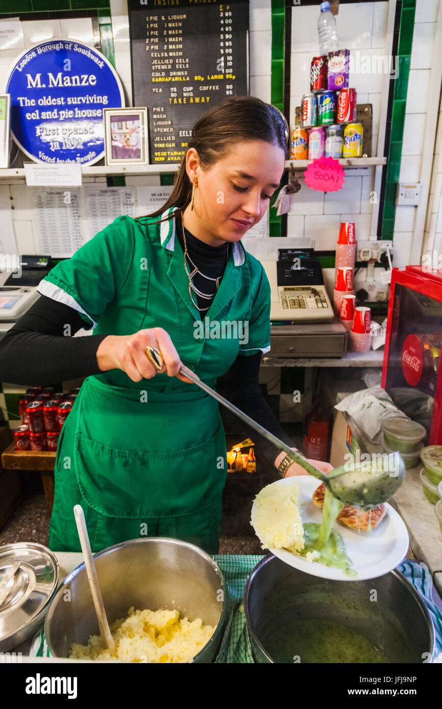 England, London, Southwark, Manze Pie und Mash-Shop, Assistent Mahlzeit von Pie und Mash und Schnaps Stockfoto