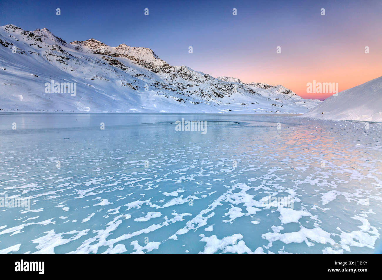 Oberfläche des Sees Bianco von Bernina, verstärkt durch die sanften Farben der Morgenröte, Kanton Graubünden, Engadin, Schweiz, Europa Stockfoto