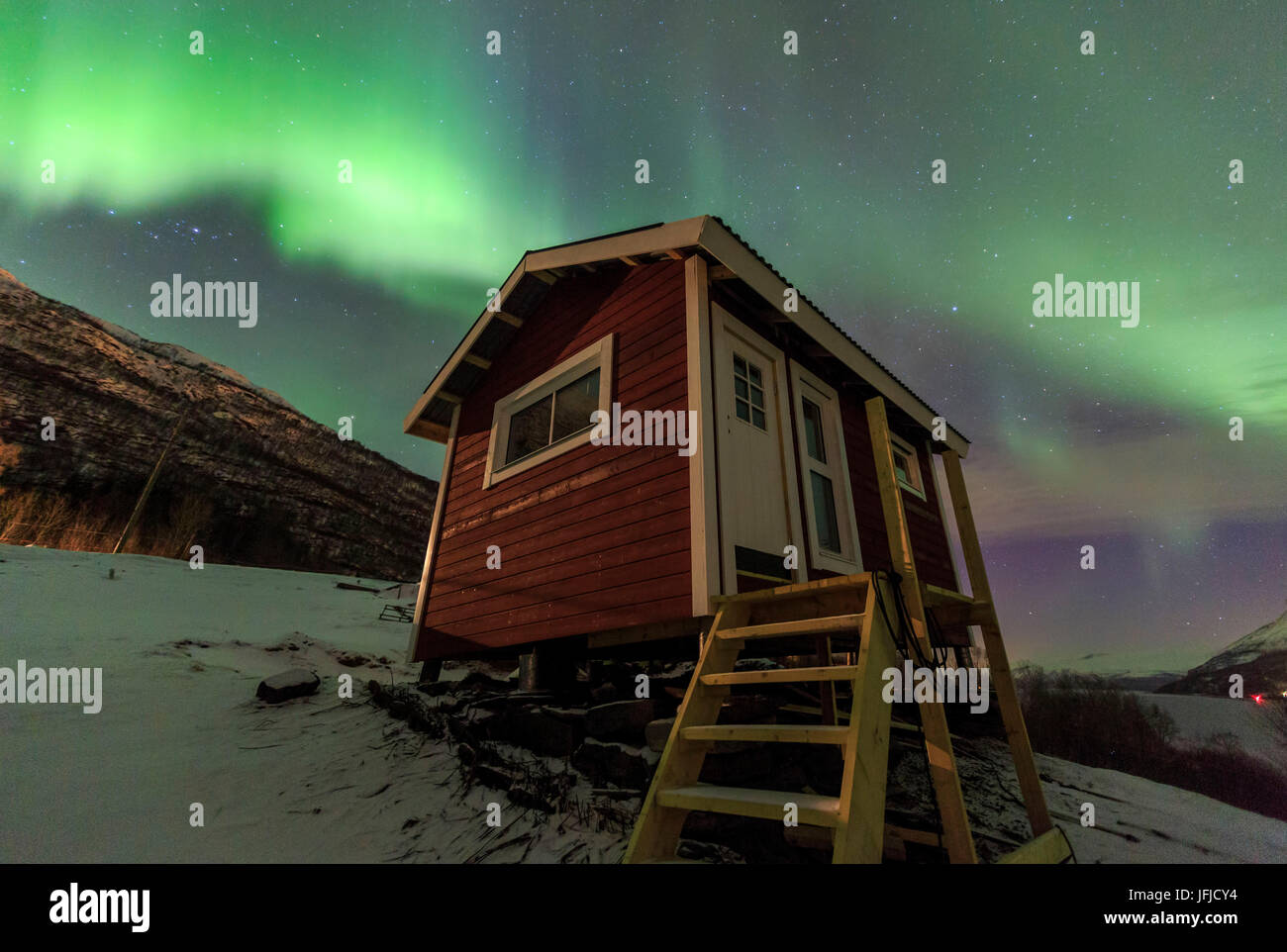Das Nordlicht erhellt die Holzhütte Oteren Storfjorden Lyngen Alpen Tromsø Lappland Norwegen Europa Stockfoto
