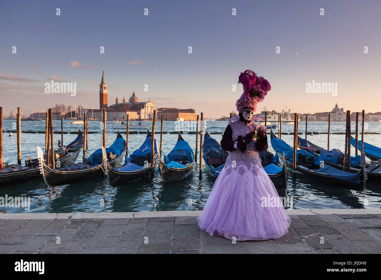 Venedig, Veneto, Italien, eine traditionelle Maske Venedig Karneval mit St-George-Insel und einige Gondeln im Hintergrund bei Sonnenuntergang, Stockfoto