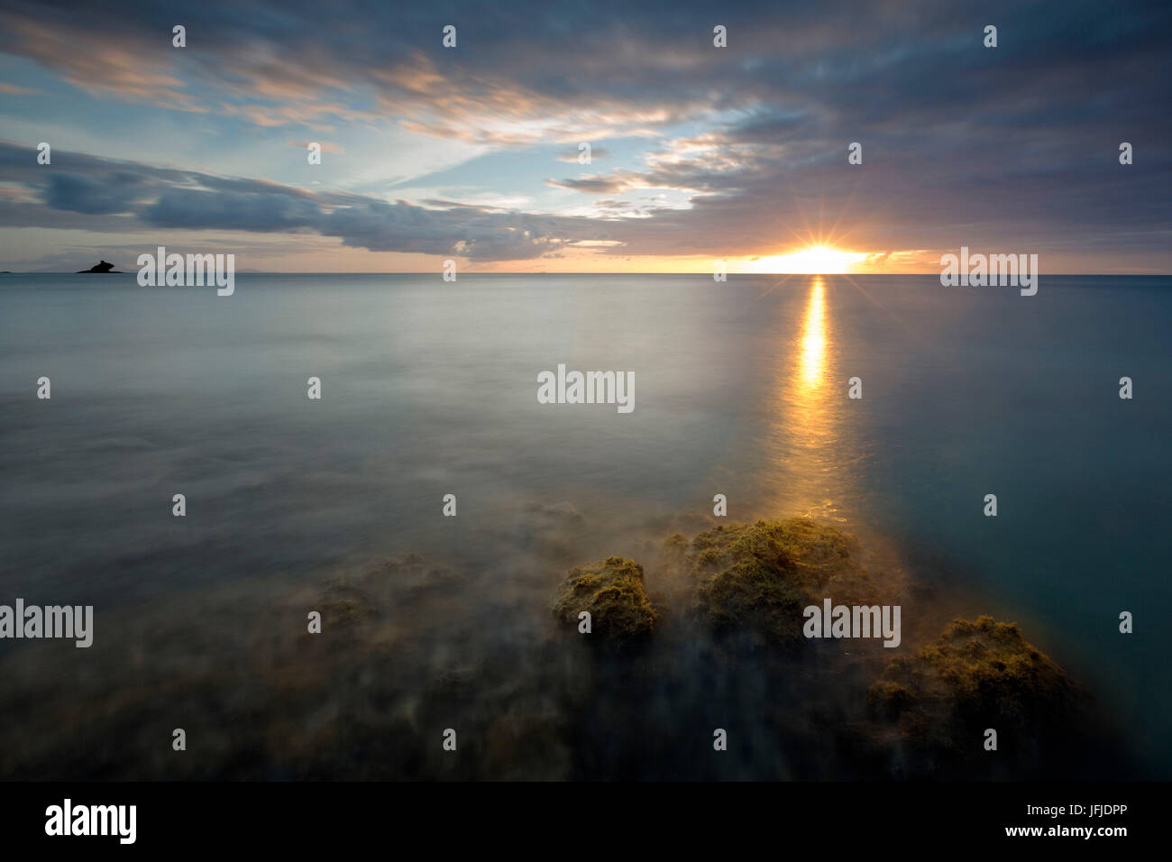 Das Licht des Sonnenuntergangs spiegeln sich in das blaue Meer Hawksbill Bay Karibik Antigua und Barbuda Leeward Islands West Indies Stockfoto