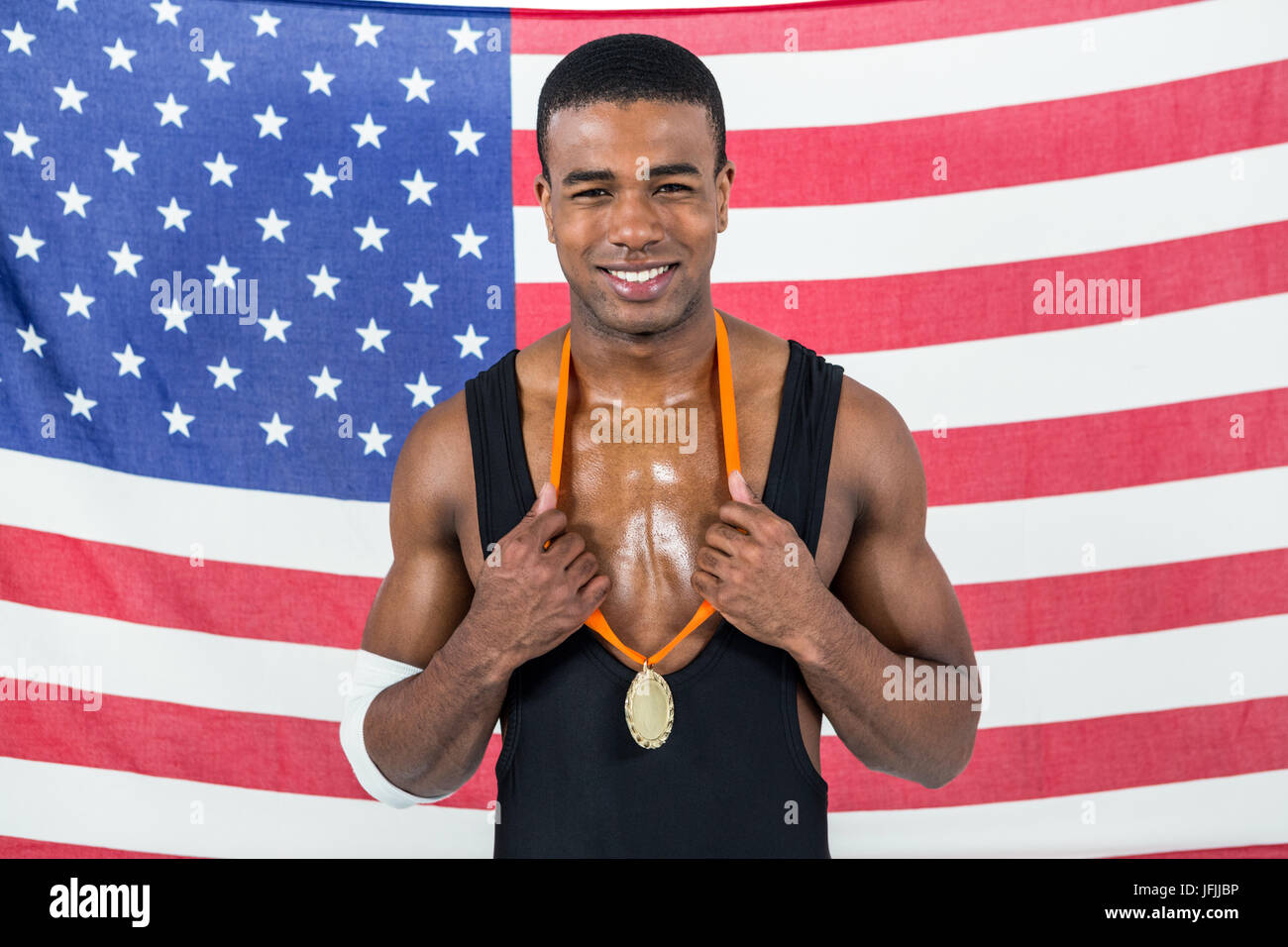 Athlet seine Goldmedaille vor amerikanischen Flagge zeigen Stockfoto