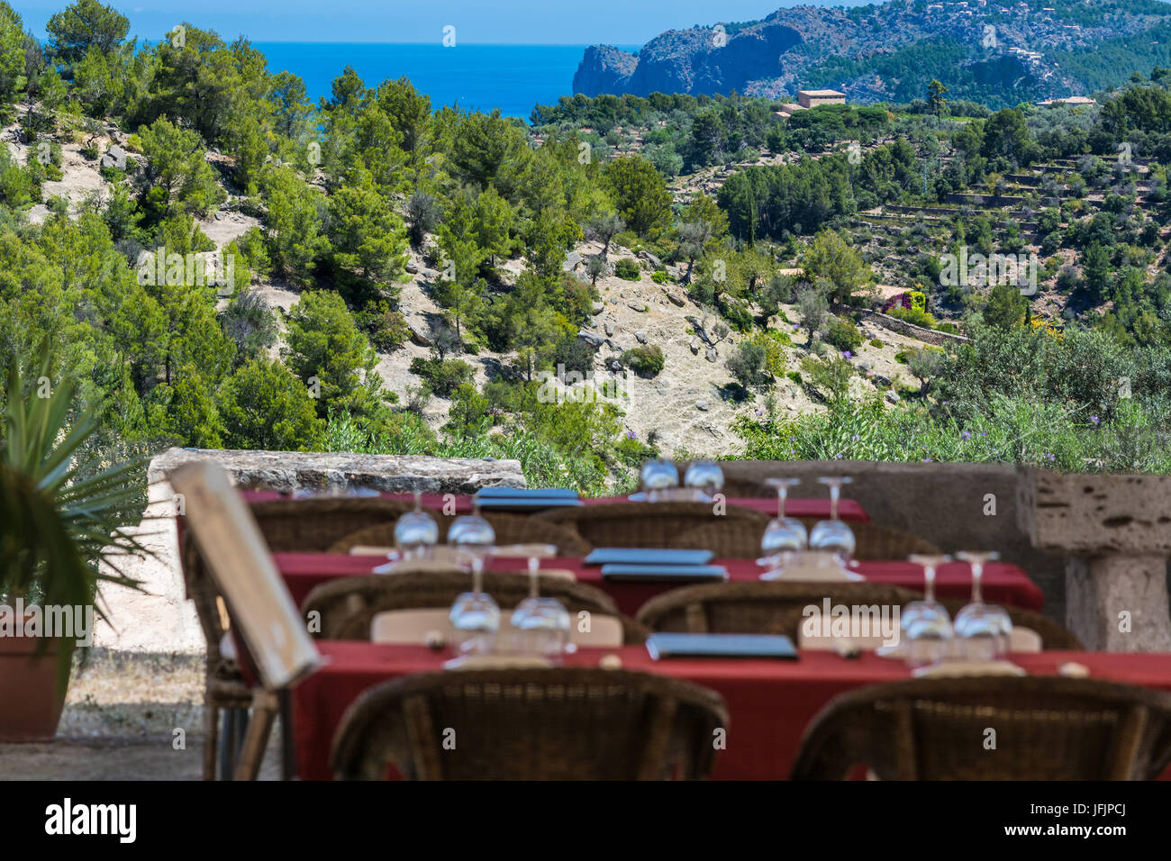 Terrasse mit Tischen, Stühlen und Meer im Hintergrund Stockfoto