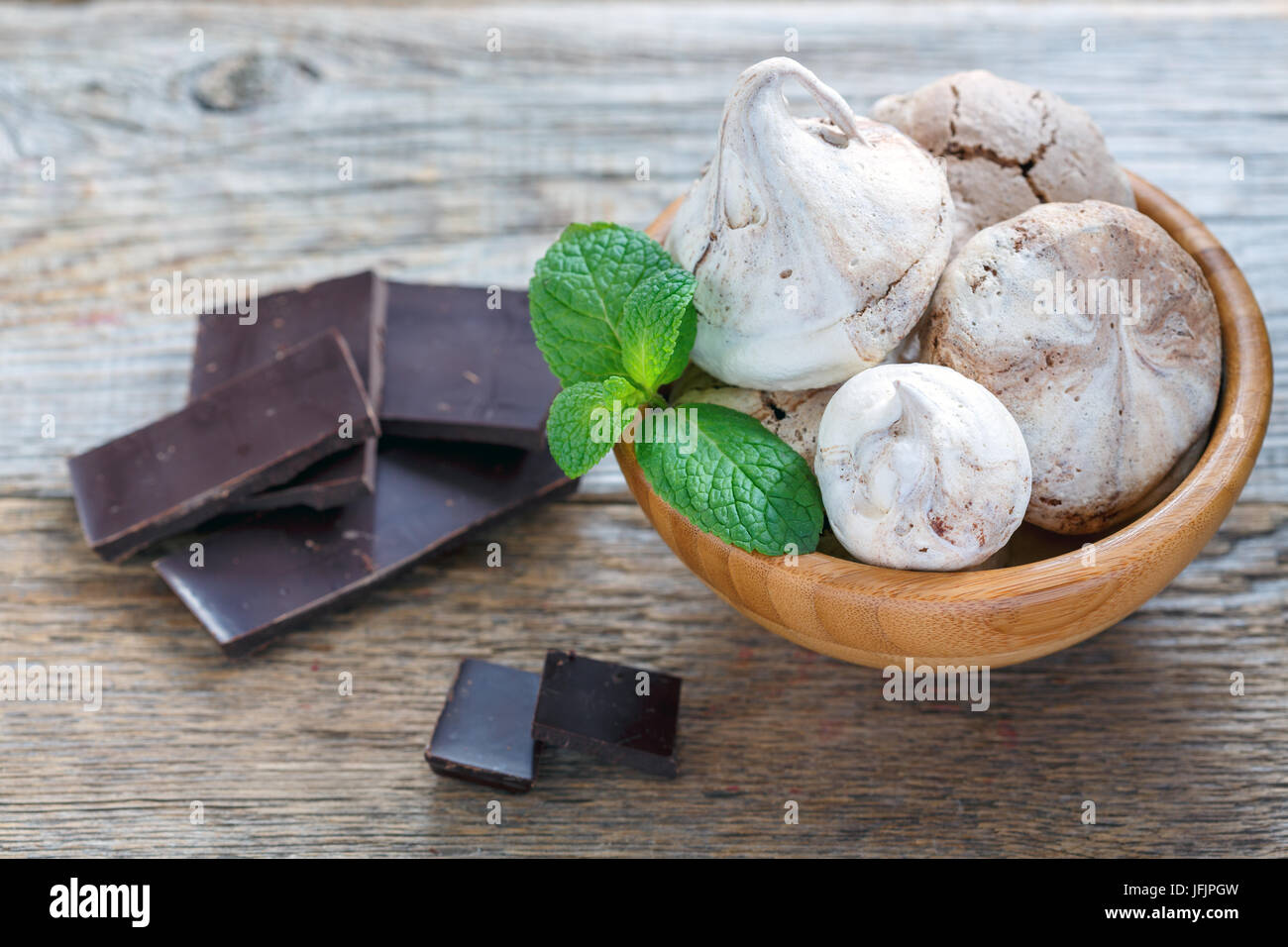 Meringue in Houten und eine schwarze Schokolade. Stockfoto