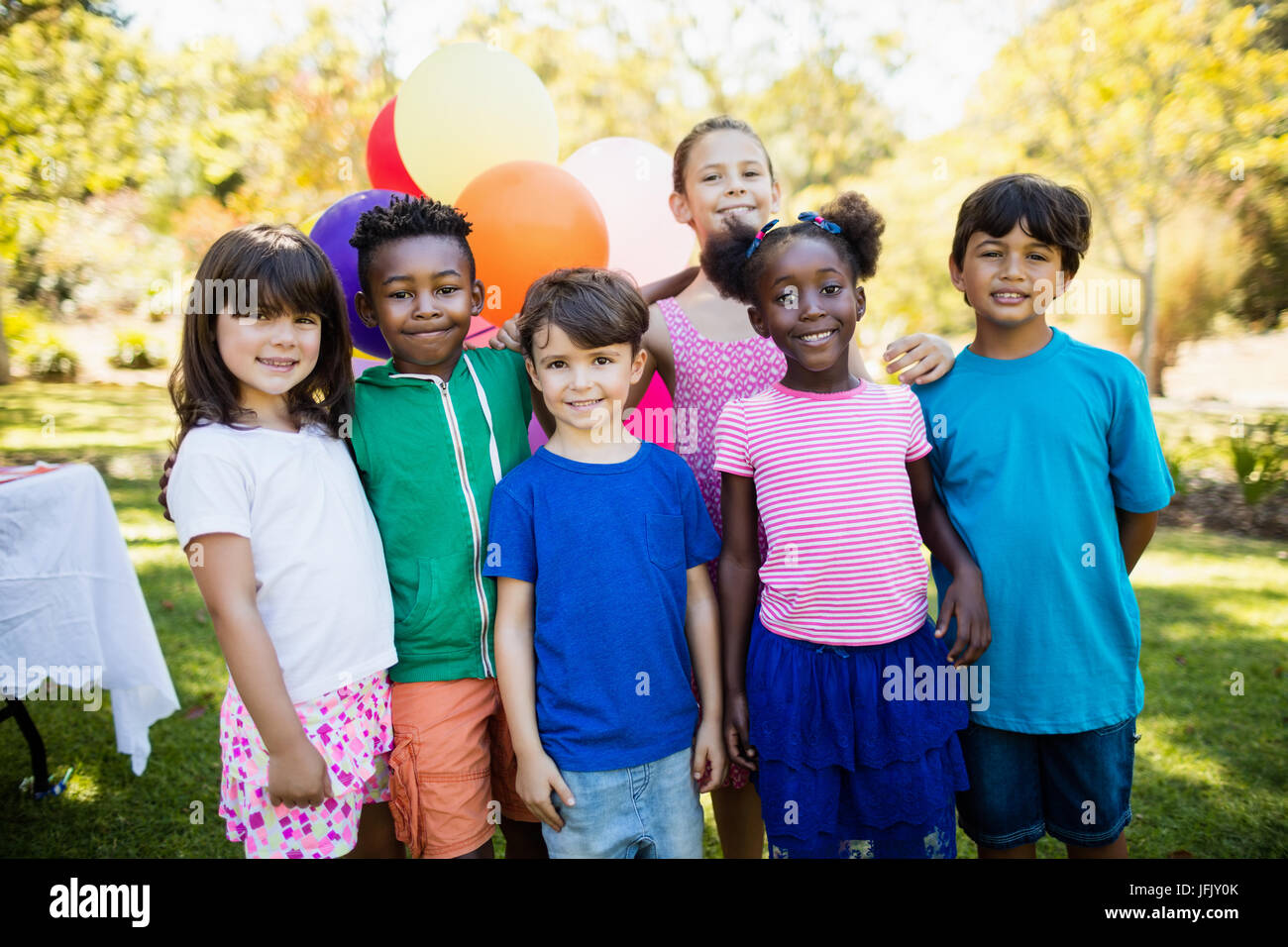 Süße Kinder stehen und posieren während einer Geburtstagsfeier Stockfoto