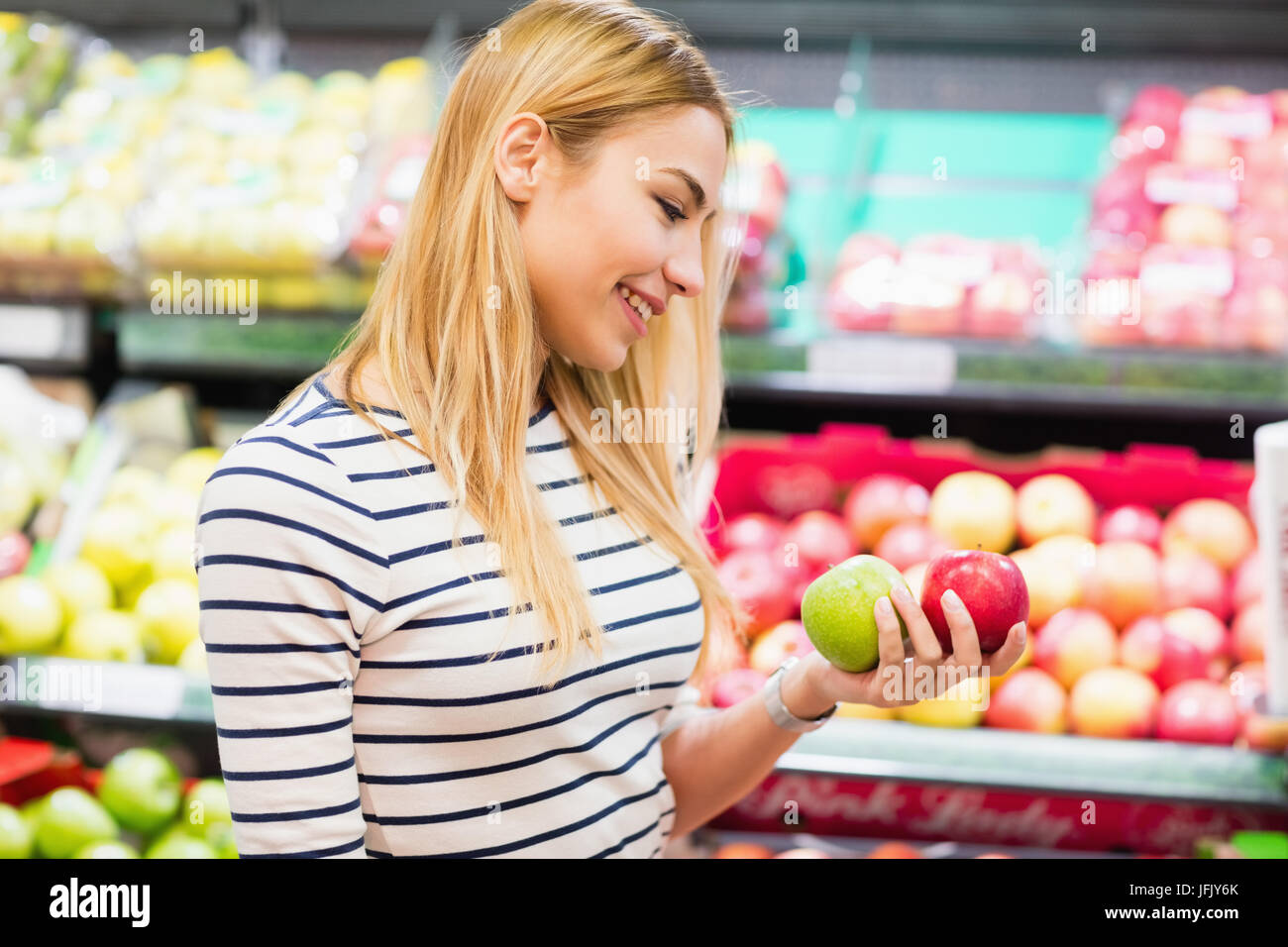 Kunden am Markt halten Früchte vor der Früchte Regal Stockfoto