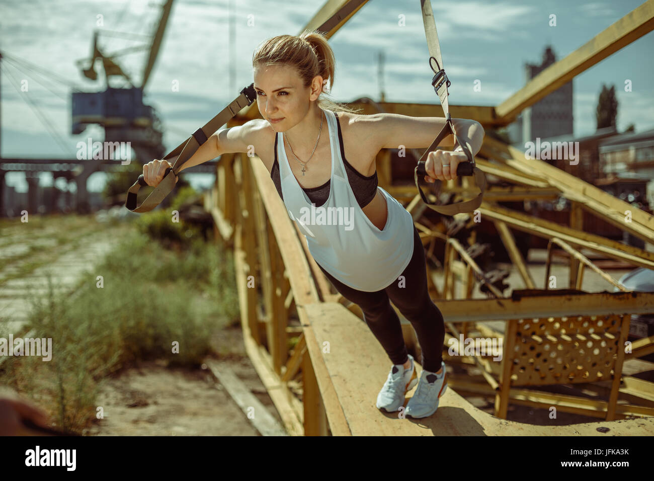 Frau dabei Oberkörper Übung Training Arme mit Trx Suspension Riemen Stockfoto