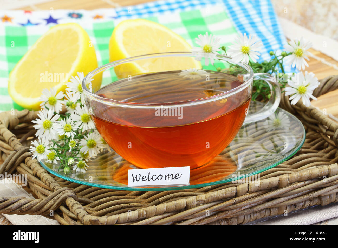 WelcomeCard mit Tasse Tee, Kamillenblüten und Zitrone Stockfoto