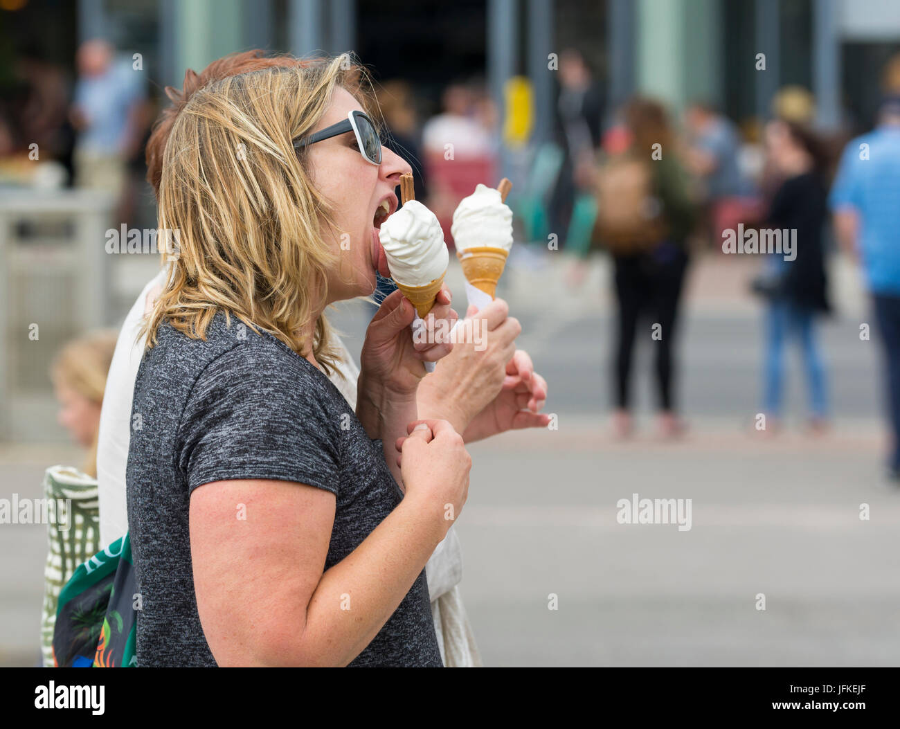 Frau essen 99 flake Eis an einem heißen Tag im Sommer in Großbritannien. Stockfoto