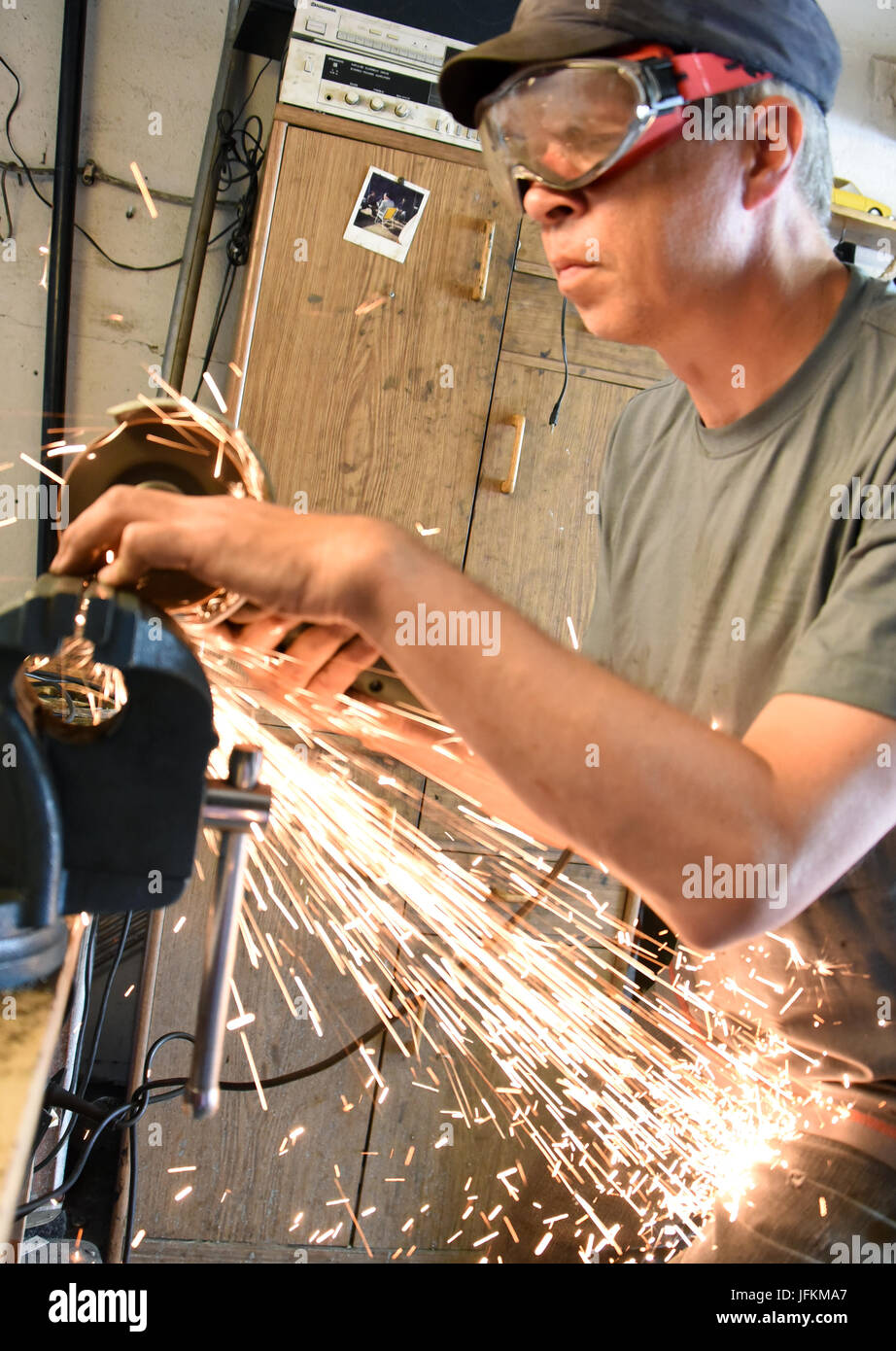 Bild des blinden Mannes, Bernd Rothig (L), arbeiten mit einem Schleifer schneiden auf einen kleinen Teil für eine mehr als 50 Jahre alten Trabant P60 in seiner kleinen Garage Werkstatt in Leipzig, Deutschland, 15. Juni 2017 aufgenommen. Der 52 Jahre alte Pyhsiotherapist ist blind, da er eine Netzhautablösung erlitten, als er 12 Jahre alt war und wahrscheinlich der einzige Amateur Kfz-Mechaniker in Deutschland ist. Als Mechaniker hat er bereits repariert und drei Trabis umgebaut. Er macht alle Metallarbeiten auf eigene Faust, während sein beste Freund Dieter Schiffel, ihm mit Elektronik hilft. Foto: Waltraud Grubitzsch/Dpa-Zentralbild/dpa Stockfoto