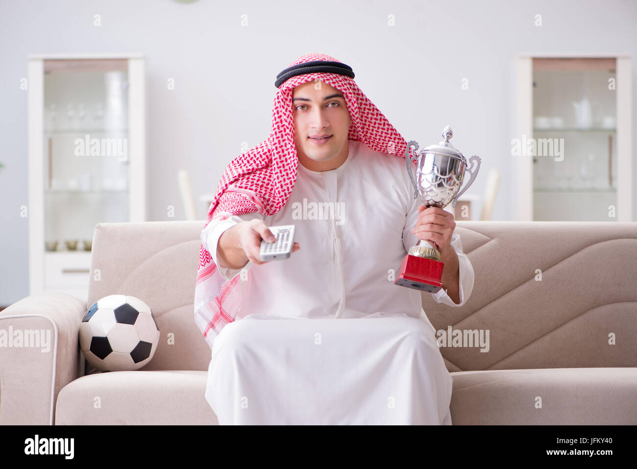 Junge arabische Mann auf Sofa Fußball gucken Stockfotografie - Alamy