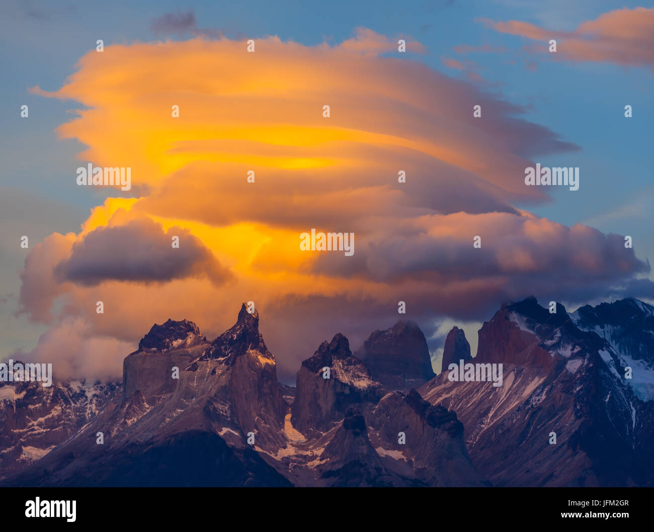 Die Wolken werden von der Sonne auf den Felsen beleuchtete Stockfoto