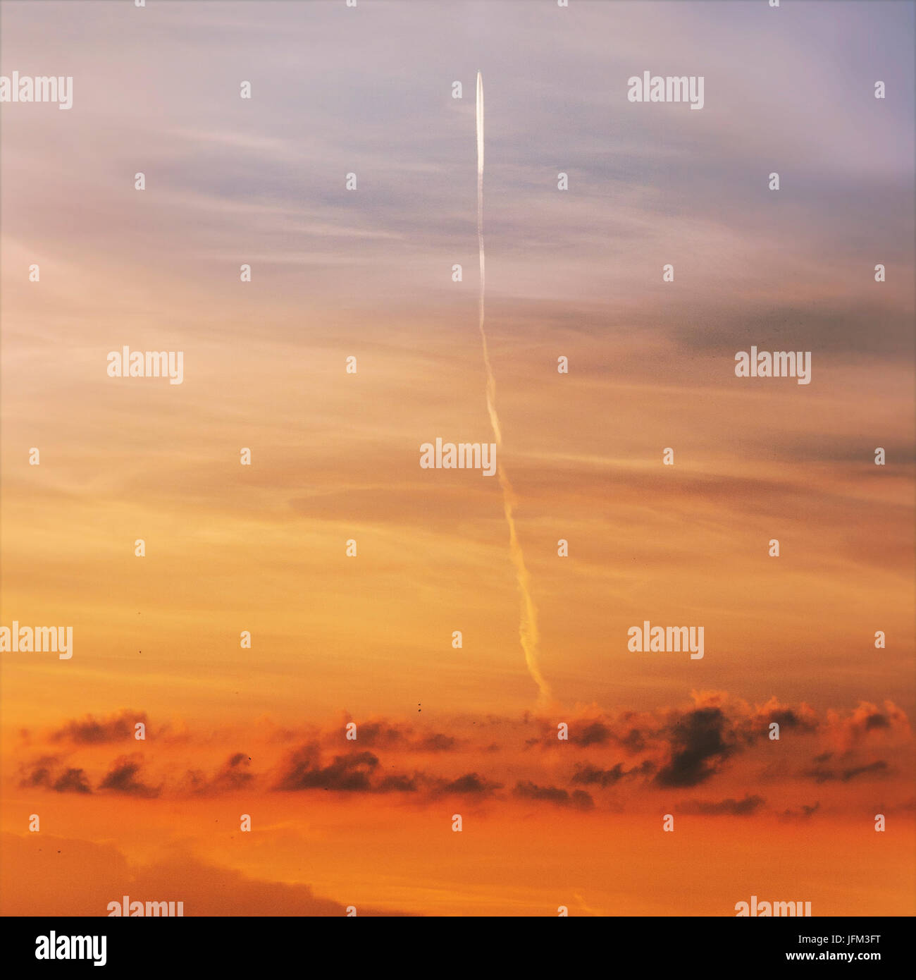 Flugzeug fliegen über orange Sonnenuntergang Himmel, der aussieht wie Rakete gestartet Stockfoto