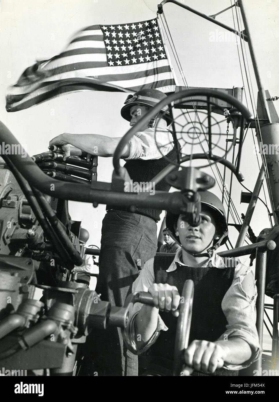 28. Juli 1943 - gehen die Sterne und Streifen Welle triumphierend als Trainer und Lader an Bord eines amerikanischen Cruiser methodisch über ihre Arbeit bei der Bombardierung die Invasion Siziliens begleitet. Stockfoto