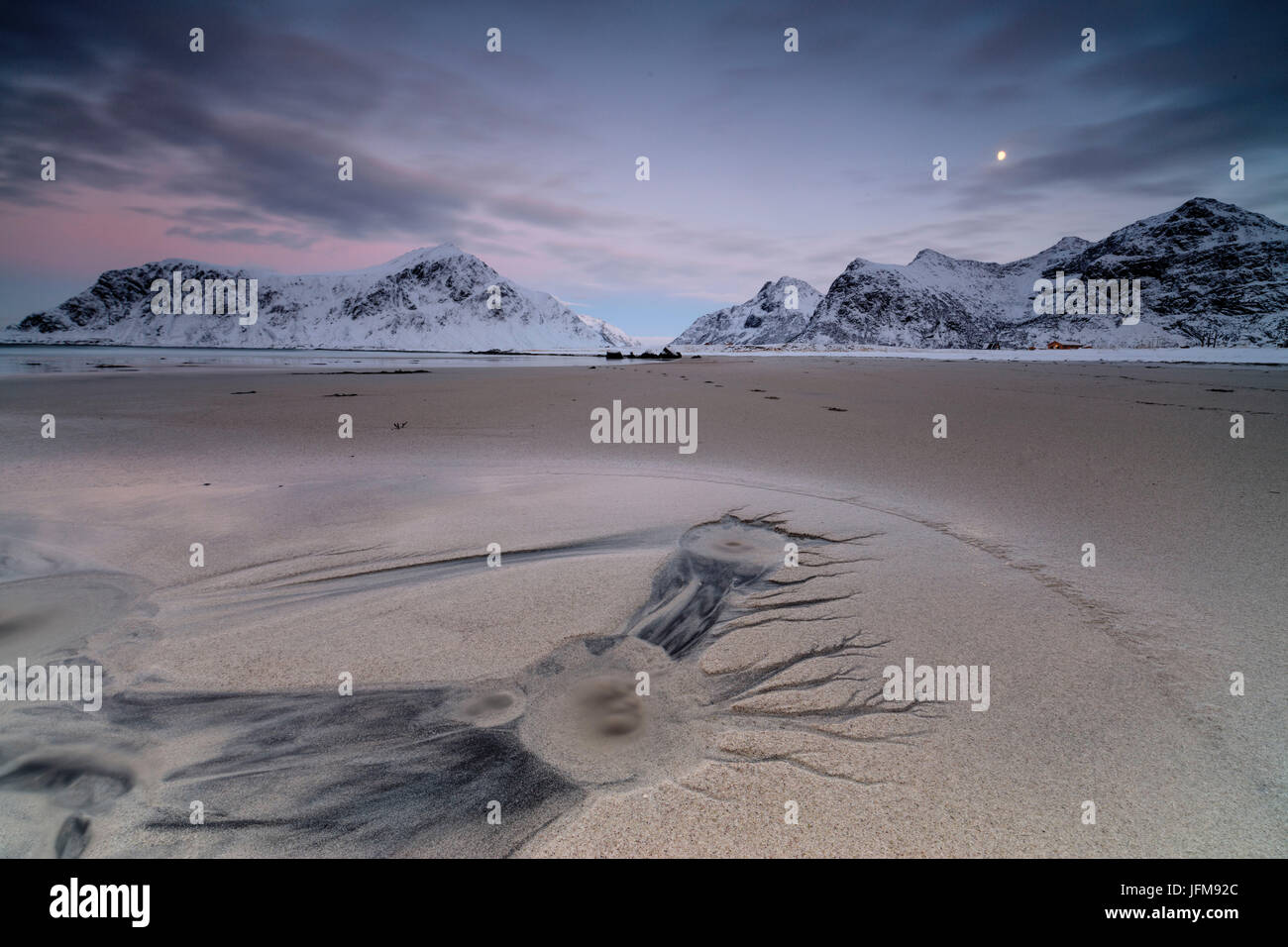 Full Moon und schneebedeckten Gipfeln in der surrealen Landschaft der Skagsanden Strand Flakstad Nordland county Lofoten Inseln Norwegen Europa Stockfoto