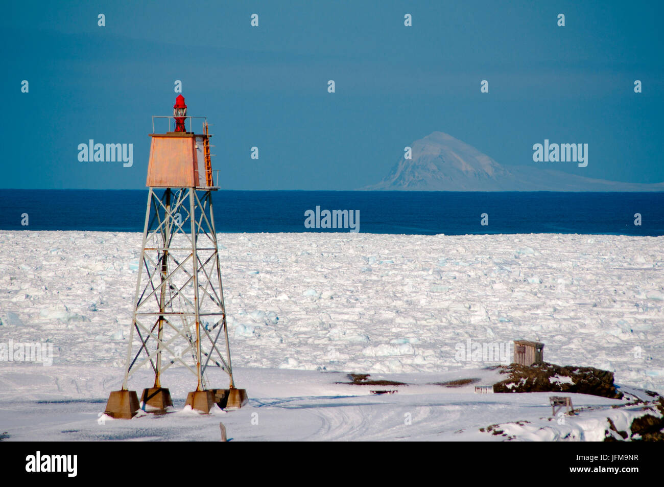 der Leuchtturm von Kapp Linnè mit Meereis und einer isolierten Berg im Rücken, Spitzbergen, Svalbard, Norwegen Stockfoto
