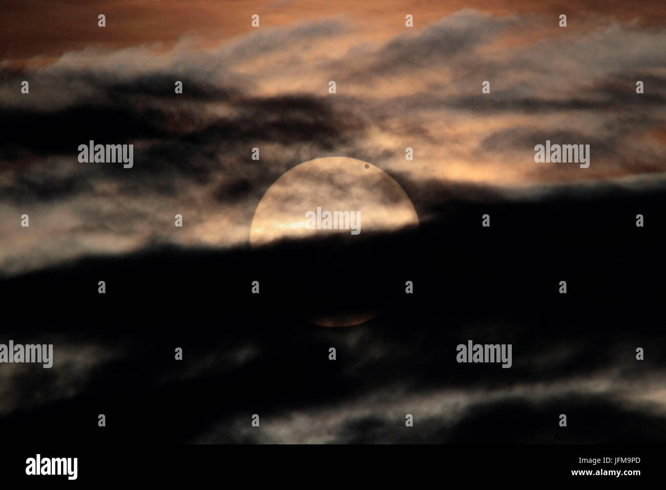 Venus-Transit über die Sonne des 5. Juni 2012, mit der Sonne hinter dunklen Wolken bei Sonnenaufgang, es wird nicht passieren erst wieder im Dezember 2117, der Aufnahme von Monte Albenza, Provinz Lecco, Lombardei, Italien Stockfoto
