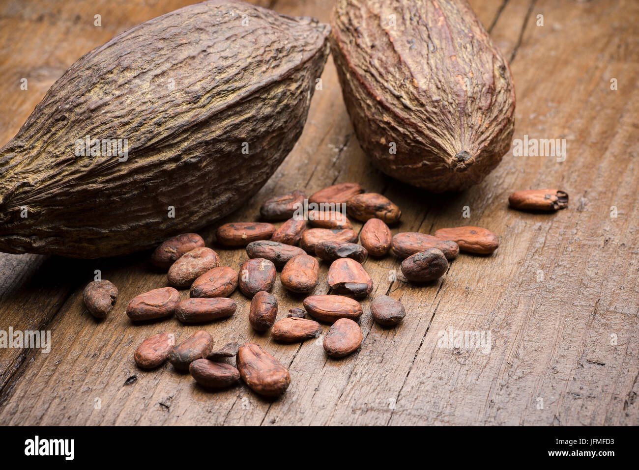 Kakaofrüchte mit Kakaobohnen auf Holztisch Stockfoto