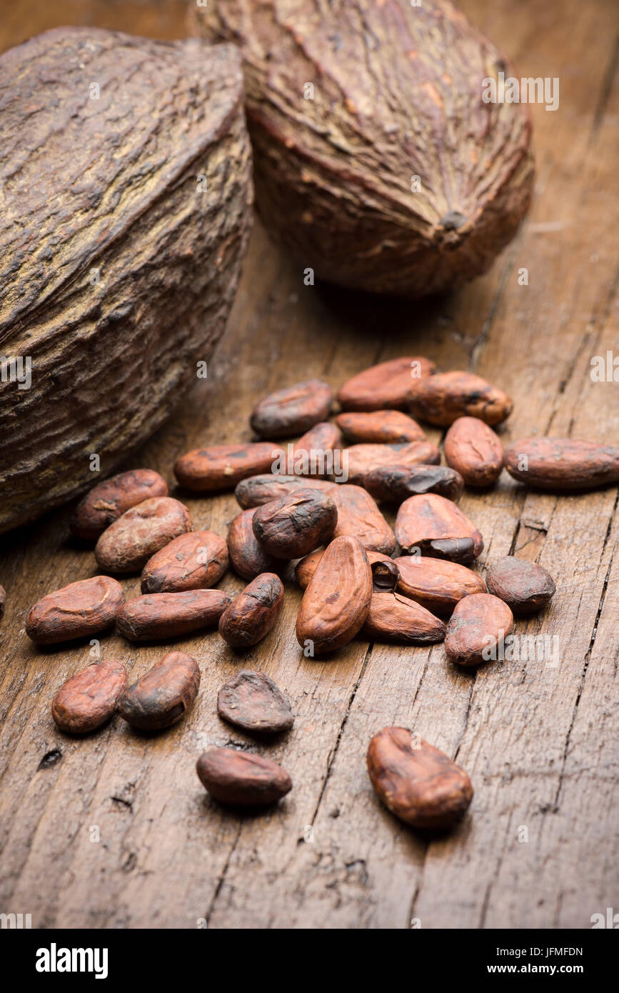 Kakaofrüchte mit Kakaobohnen auf Holztisch Stockfoto