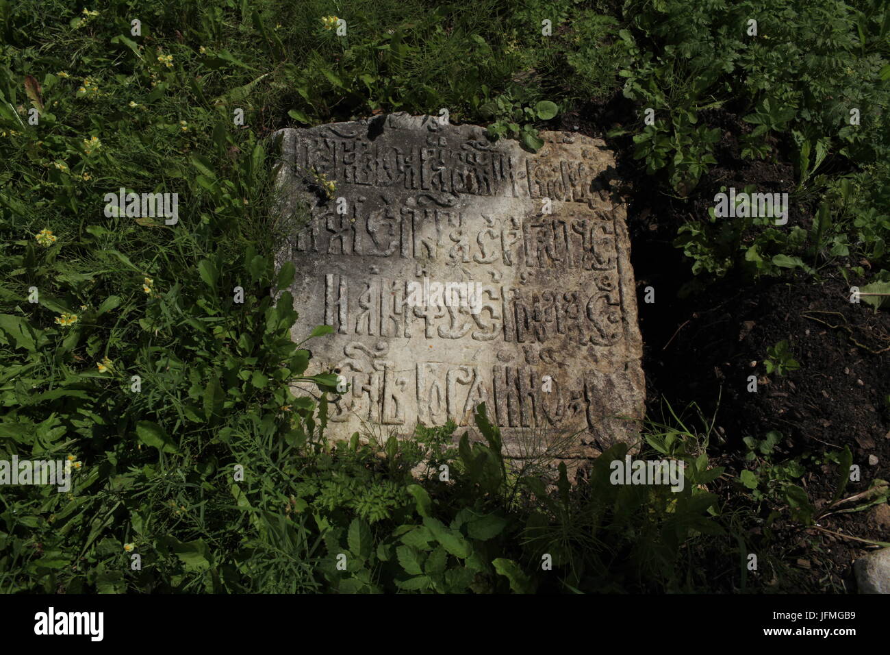 Fragment der alten Grabstein-Inschrift in der alten Sprache nah an Stockfoto