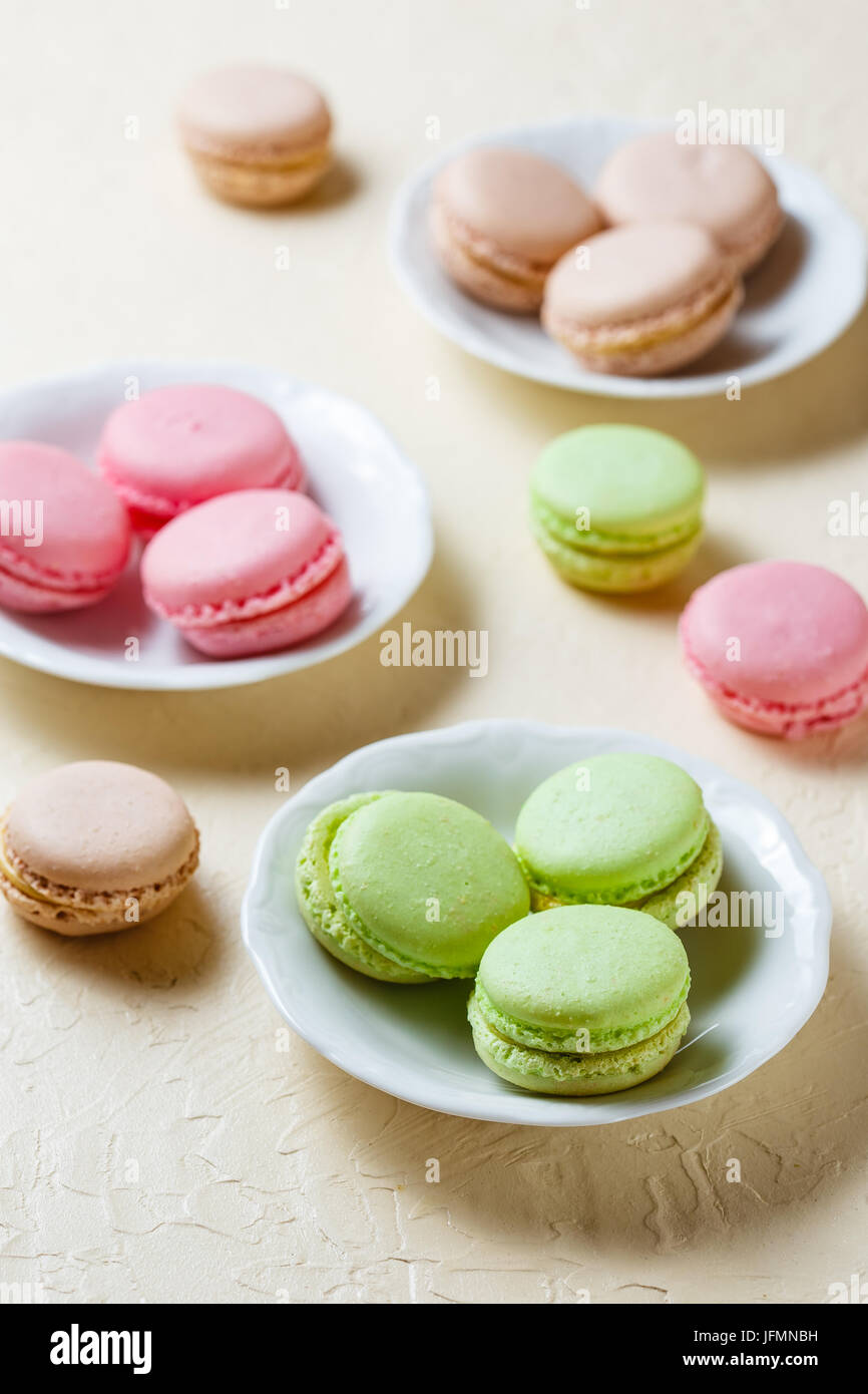 Drei Platten mit Makronen rosa, grün und braun Farbe Stockfoto
