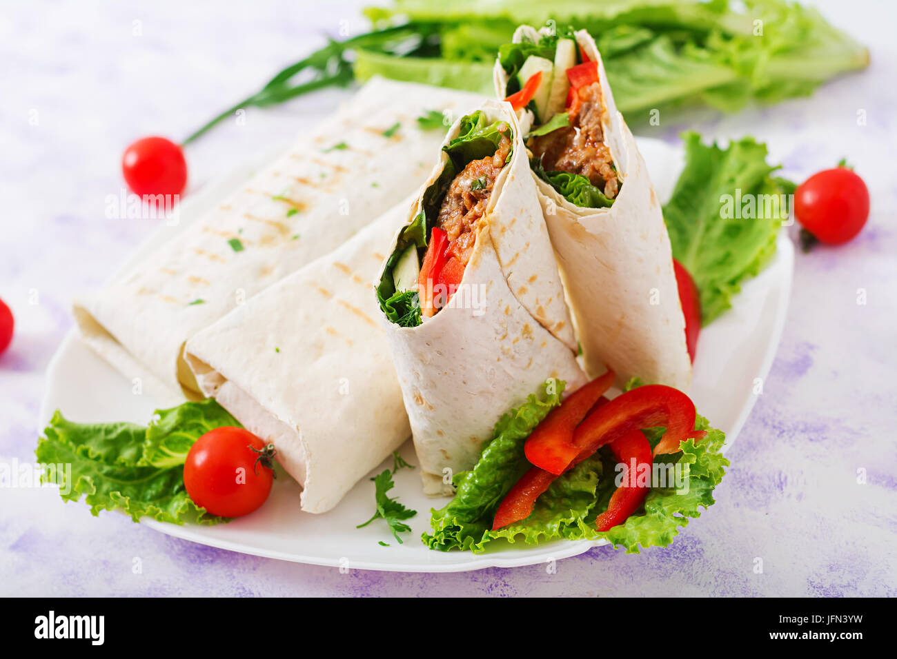 Burritos Wraps mit Hackfleisch und Gemüse auf einem hellen Hintergrund. Stockfoto