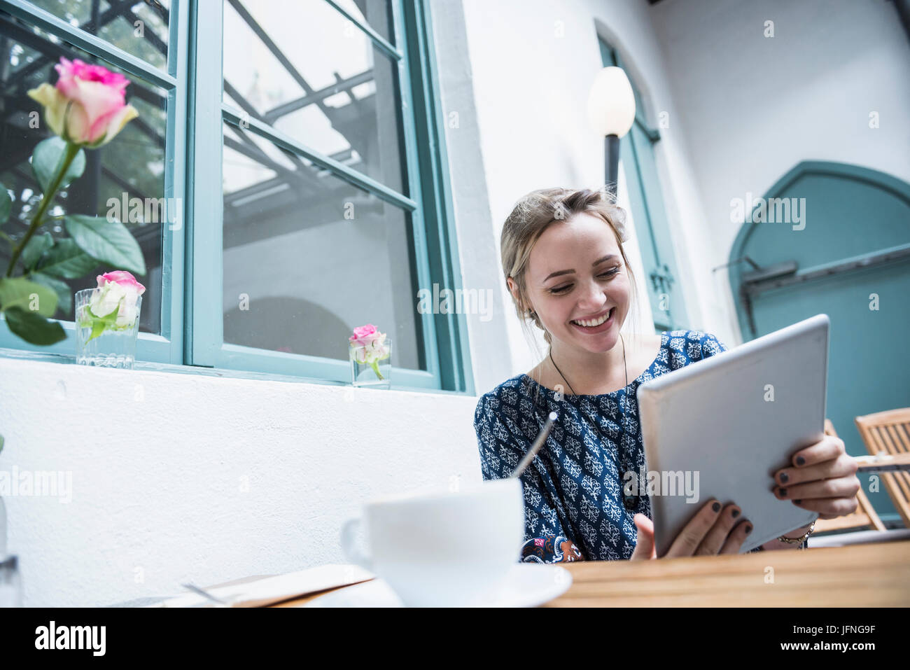Lächelnde junge Frau mit digital-Tablette im Coffee shop Stockfoto