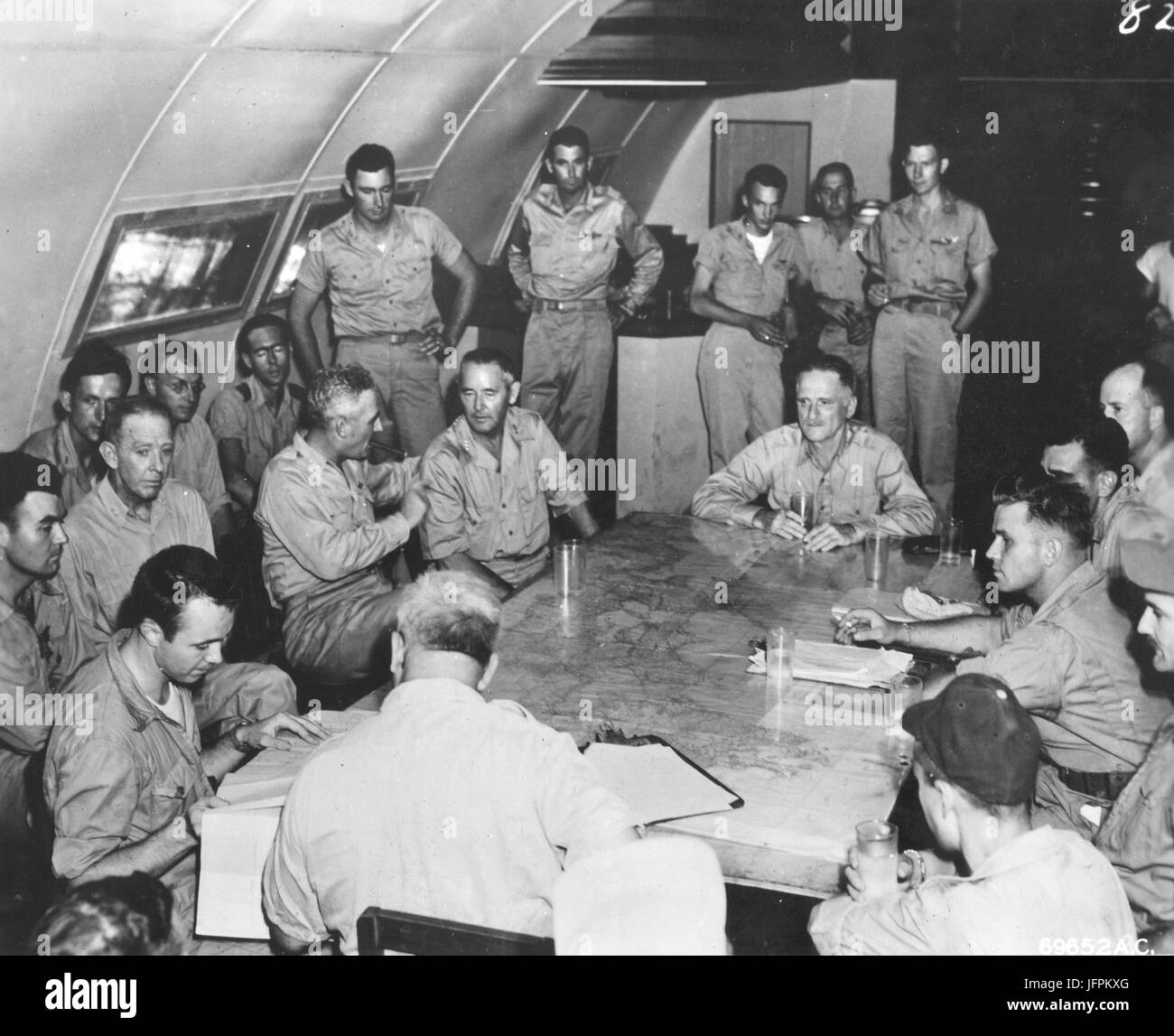 Lt. General Nathan Twining, Generalleutnant Barney M. Giles und General Carl Spaatz (von links nach rechts um Tisch) besuchen die Nachbesprechung der 509. Composite-Gruppe, der die erste Atombombenabwürfe auf Hiroshima, Japan beteiligt. Tinian, 6. August 1945. Stockfoto
