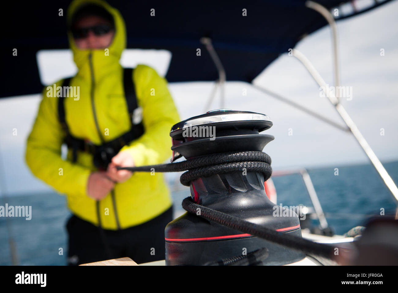 Seemann Jacke zieht die Seilwinde auf Segelyacht Stockfoto