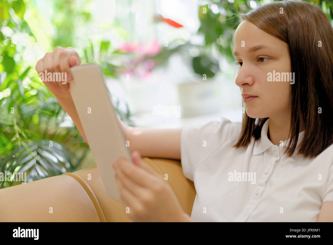 Personen: junges Mädchen, Studentin, die Nutzung von Tablet-PC oder e-Book-Reader, in einer Bibliothek oder im Buchhandel, selektiven Fokus auf Gesicht Stockfoto