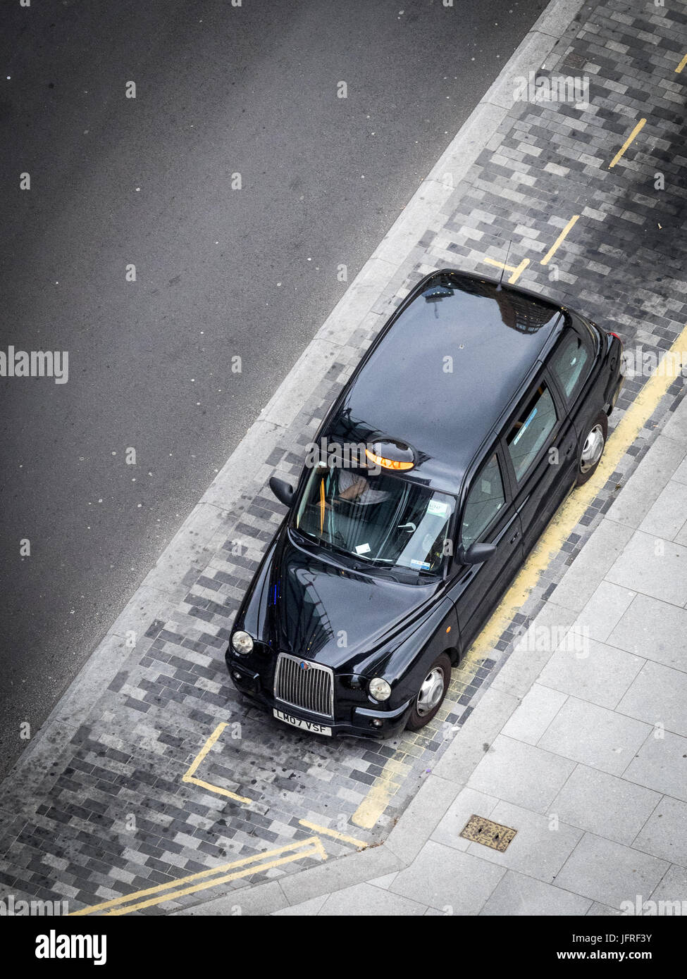 London Taxi Waiting - ein Luftschuss eines einsamen Londoner Taxis von oben, das auf Kunden in der Nähe der Tate modern Art Gallery in der Londoner South Bank wartet Stockfoto